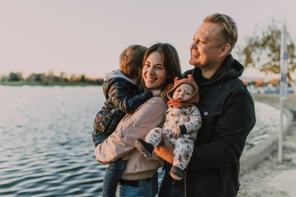 A joyful family with children enjoying a sunset by the lake, capturing love and togetherness.